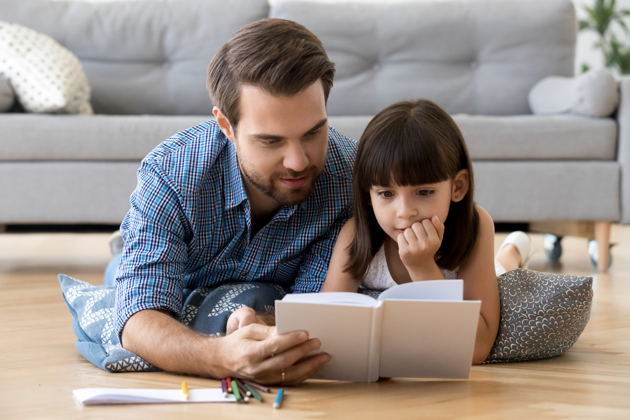 A father teaching his daughter how to read.