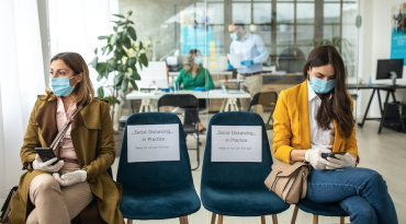 Two women sitting six feet apart to ensure social distancing.