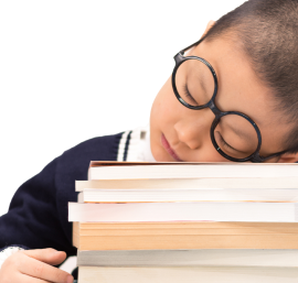 Child with glasses resting head on a stack of books.