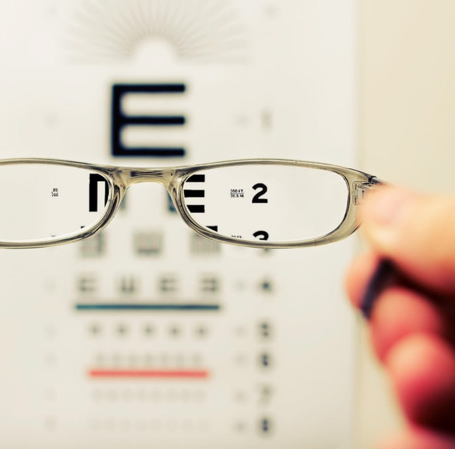 glasses in front of a vision chart.