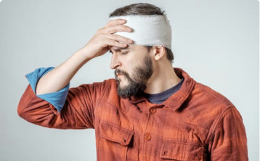 Man with bandage on head suffering from headache.