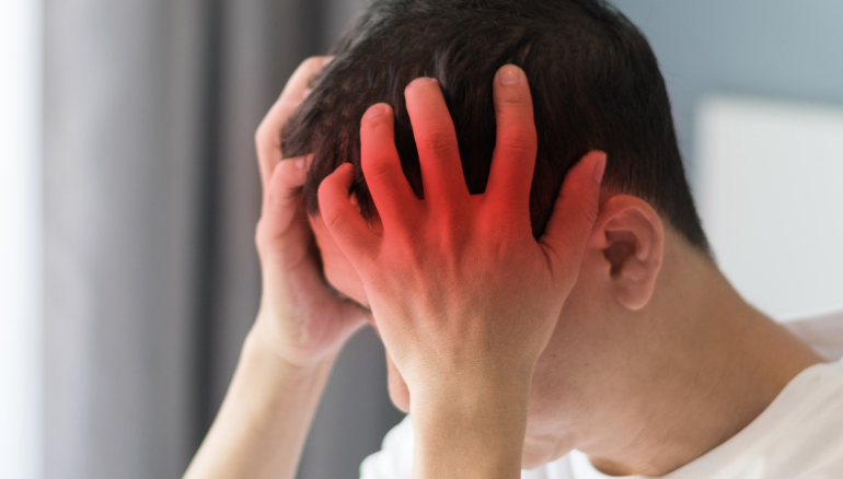 Man holding head and suffering from headache symptoms.