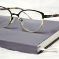 A pair of glasses on top of a notebook - Vision Specialists of Michigan